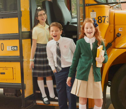 Three students in French Toast uniforms getting off a school bus