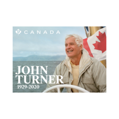 Stamp with &quot;John Turner&quot; and text. He is steering a boat on the water on an overcast day, smiling in front of a Canada flag.